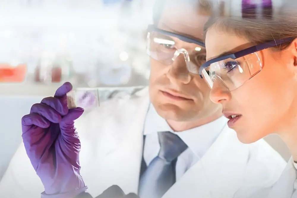 Lica žene i muškarca koji posmatraju uzorak u laboratoriji