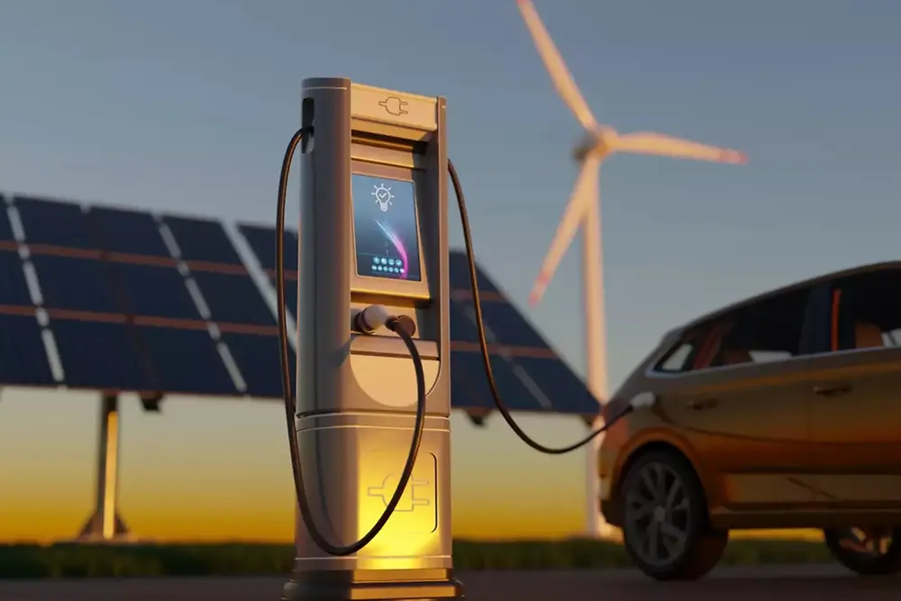 Stanica za punjenje električnih vozila sa solarnim panelima i vetroturbinama u pozadini.