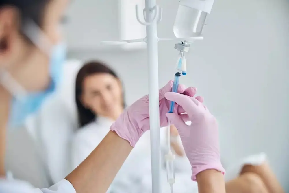 Medicinski radnik drži infuzionu kesu u zdravstvenom okruženju.
