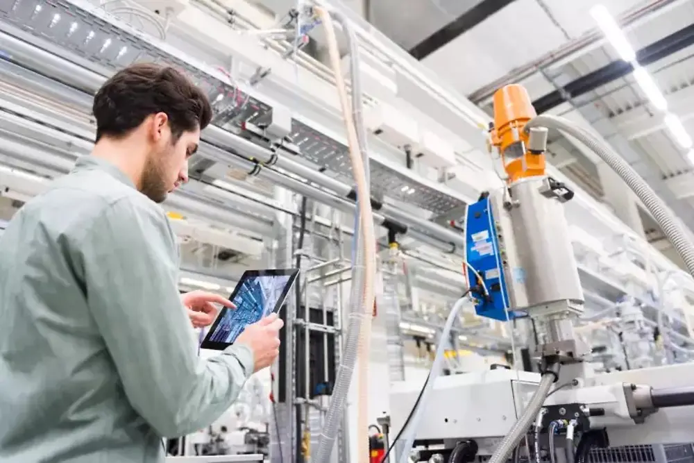 Radnici upravljaju mašinama unutar industrijskog proizvodnog pogona.